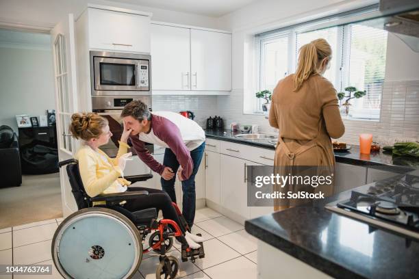 family with disabled daughter in the kitchen - teenager cerebral palsy stock pictures, royalty-free photos & images