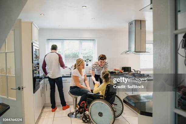 vie de famille dans la cuisine avec la fille handicapée - sclérose latérale amyotrophique photos et images de collection
