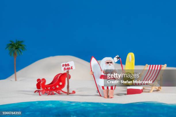 santa claus takes a surfing holiday at the beach - jandals foto e immagini stock