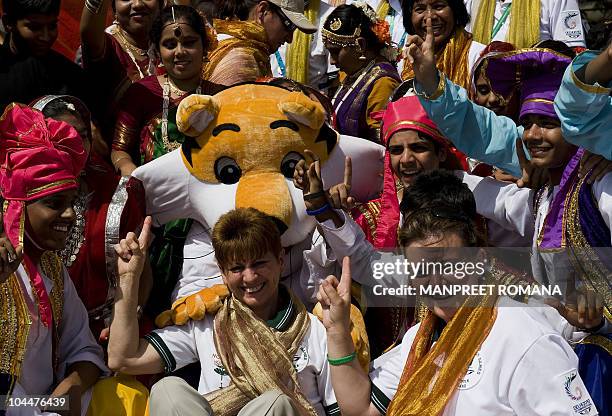 Commonwealth Games Norfolk Island team members have their picture taken with Games mascot Shera the Tiger and Indian performers who danced during the...