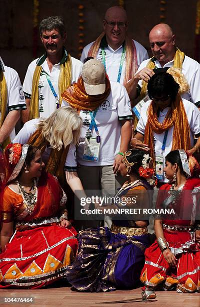 Commonwealth Games Norfolk Island team members have their picture taken with Indian performers who danced during the flag hoisting cermony at the...