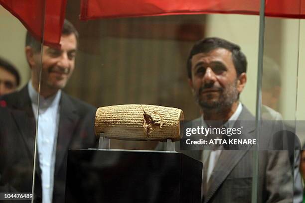 Iranian President Mahmoud Ahmadinejad and the head of the Iran's presidential office, Esfandyar Rahim Mashaie view the Cyrus Cylinder, at the...