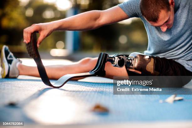 uomo disabile che si allunga all'aperto - piede artificiale per lo sport foto e immagini stock