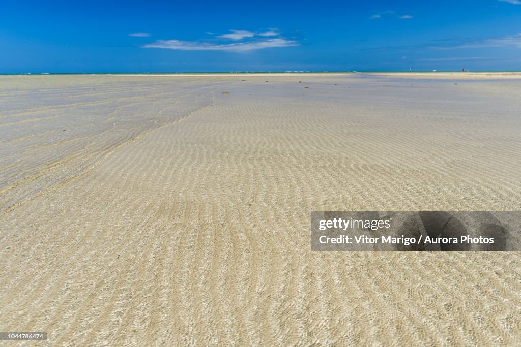 Scenery with shallow water over sand in tropical beach in Morro de Sao Paulo, south Bahia state, Brazil