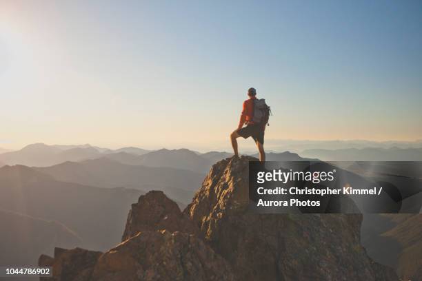 photograph of adventurous backpacker standing on mountain peak, north cascades national park, washington state, usa - top hat stock-fotos und bilder