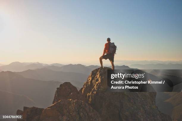 photograph of adventurous backpacker standing on mountain peak, north cascades national park, washington state, usa - washington state mountains stock pictures, royalty-free photos & images