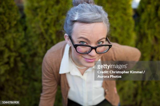 photograph of young woman dressed as old woman with gray hair and eyeglasses, vancouver, british columbia, canada - woman silver hair young ストックフォトと画像