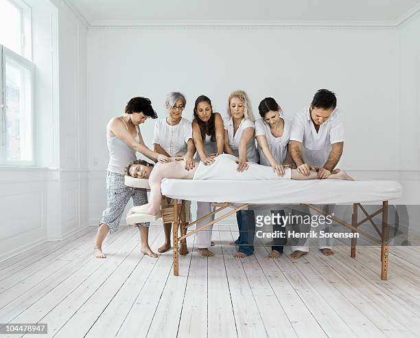 six masseurs massaging a male patient - massage funny stock pictures, royalty-free photos & images