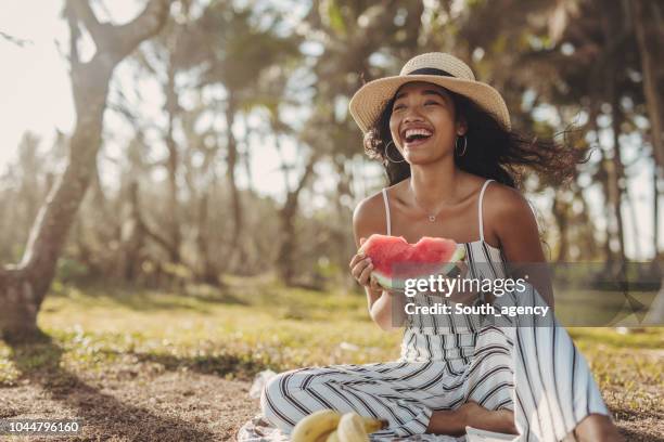 beautiful young women sitting in the nature and eating watermelon - woman eating fruit stock pictures, royalty-free photos & images