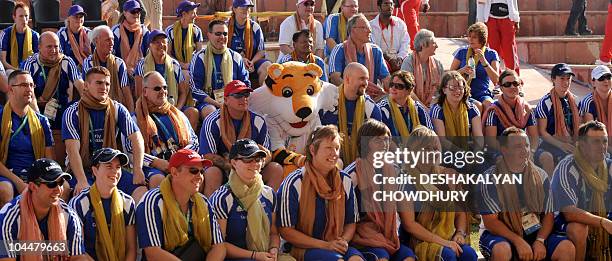 Members of the Scottish team pose for a family photo with Shera, the New Delhi Commonwealth Games mascot during the flag hoisting cermony at the...