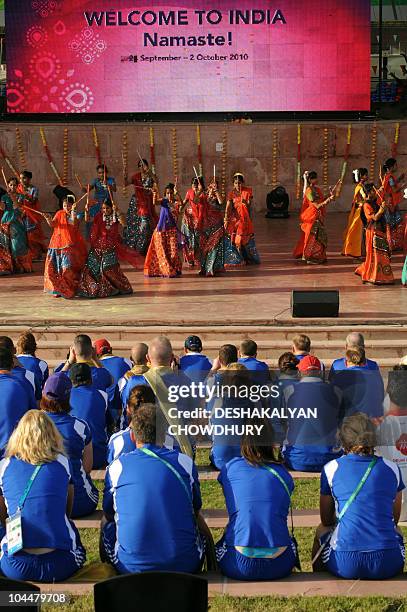 Members of the Scottish team watch a performance during the flag hoisting cermony at the Games' village in Delhi on September 27, 2010. The...