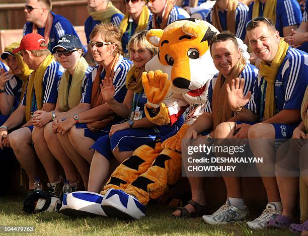 Members of the Scottish team pose for a family picture with Shera, the New Delhi Commonwealth Games mascot during the flag hoisting cermony at the...