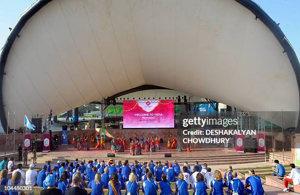 Members of the Scottish team watch a performance during the flag hoisting cermony at the Games' village in Delhi on September 27, 2010. The...