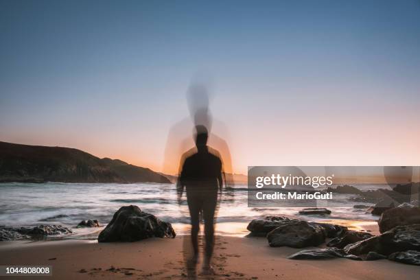 jonge man in motion rubriek aan de zee bij zonsondergang - disappear stockfoto's en -beelden