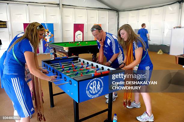 Members of the Scottish team play a game of table football in the recreational area at the Commonwealth Games' village in Delhi on September 27,...