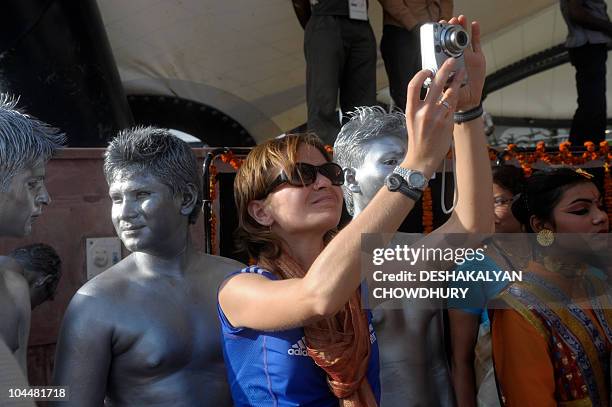 Member of the Scottish team takes a photograph during the flag hoisting cermony at the Games' village in Delhi on September 27, 2010. The contingent...