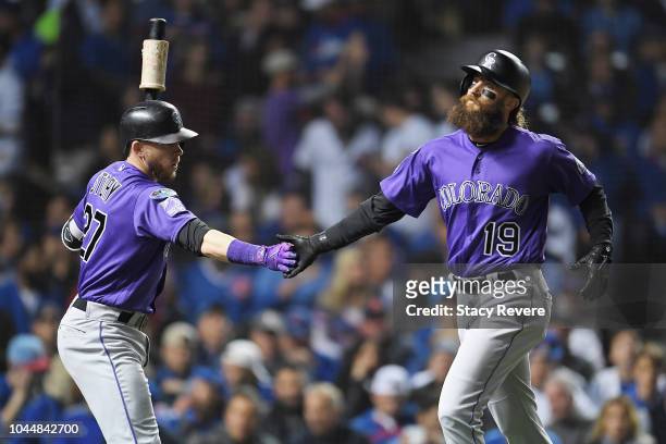 Charlie Blackmon celebrates with Trevor Story of the Colorado Rockies after scoring a run in the first inning against the Chicago Cubs during the...