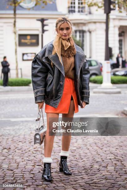 Sarah Ellen, wearing a beige turtleneck sweater, orange mini skirt, black boots, black oversize jacket and silver bag, is seen after the Miu Miu show...