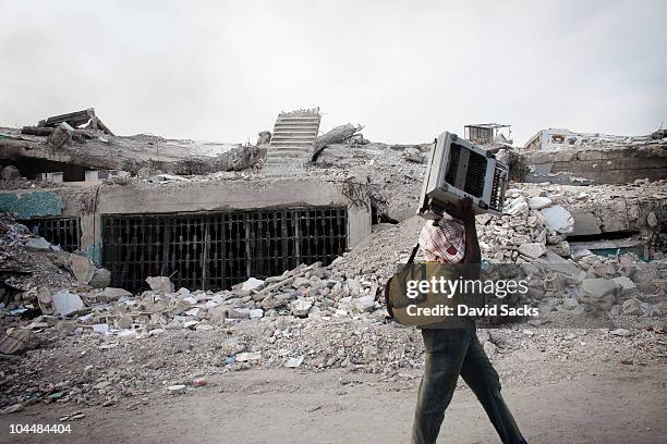 teenage boy carrying a typewriter by rubble - haitianas - fotografias e filmes do acervo