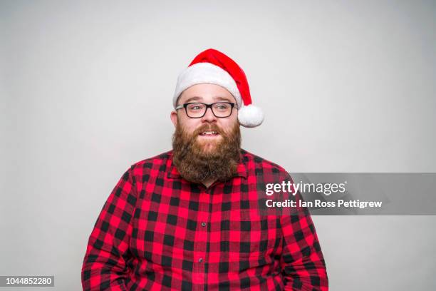 young santa claus wearing a plaid shirt - santa hat and beard stock pictures, royalty-free photos & images