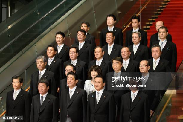 Shinzo Abe, Japan's prime minister, front row center, poses for a group photograph with his new cabinet members at the Prime Minister's official...