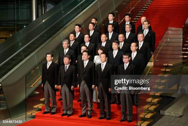 Shinzo Abe, Japan's prime minister, front row center, poses for a group photograph with his new cabinet members at the Prime Minister's official...