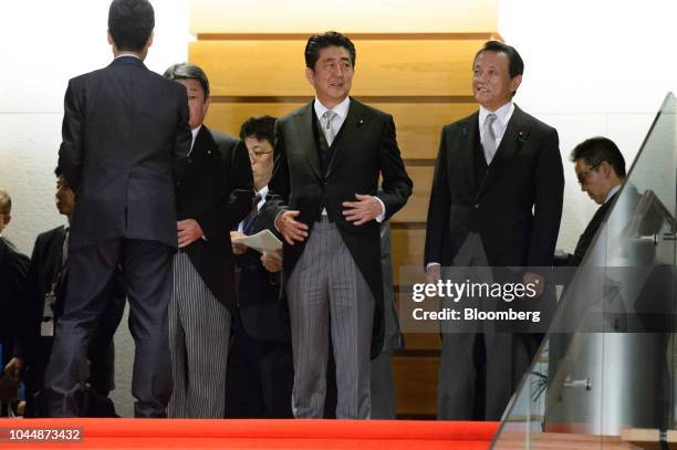 Shinzo Abe, Japan's prime minister, center, speaks with Taro Aso, deputy prime minister and finance minister, right, before posing for a group...