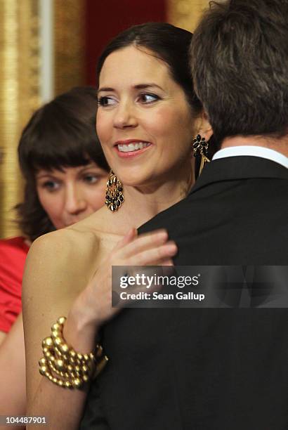 Danish Crown Princess Mary, who is pregnant with twins, places a hand on the shoulder of her husband, Danish Crown Prince Frederik, during a...