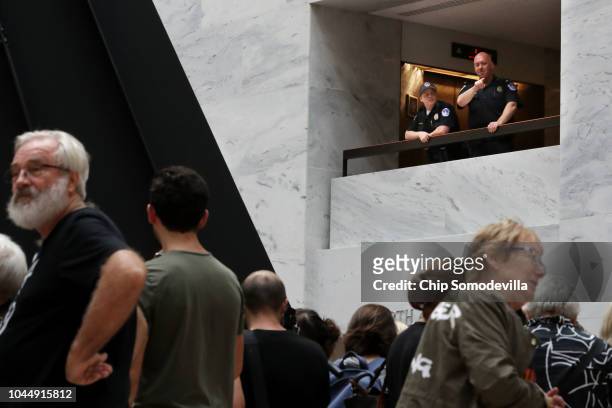 Capitol Police count demonstrators as they gather in the atrium of the Hart Senate Office Building on Capitol Hill September 26, 2018 in Washington,...