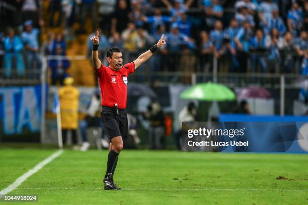 Referee Roberto Tovar checks the Video Assistant Referee before shows the red card to Luchetti of Atletico Tucuman during the match between Gremio...