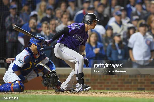 Tony Wolters of the Colorado Rockies hits a RBI single to score Trevor Story in the thirteenth inning against the Chicago Cubs during the National...