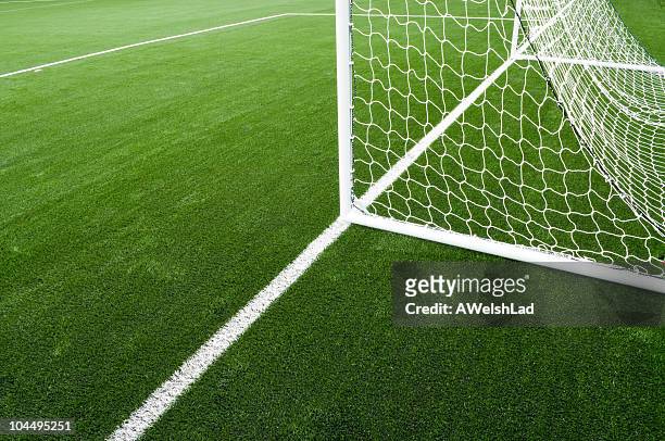 soccer net and field on bright green artificial turf - football field stockfoto's en -beelden