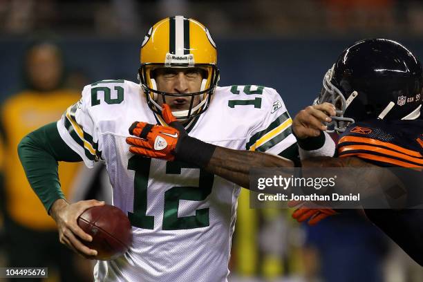 Aaron Rodgers of the Green Bay Packers attempts to escape pressure from Mark Anderson of the Chicago Bears in the first half at Soldier Field on...