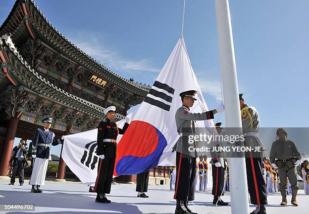 South Korean honour guards hoist the national flag to celebrate the recapture of its capital from North Korea in a ceremony marking the 60th...