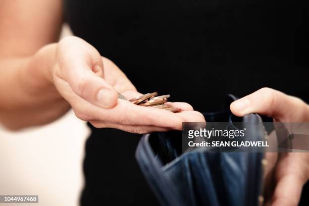 woman holding money over purse - wirtschaftskrise stock-fotos und bilder