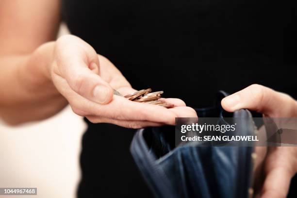 woman holding money over purse - coins stockfoto's en -beelden