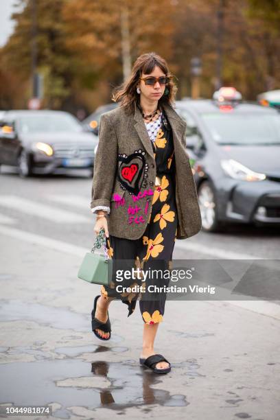 Natasha Goldenberg wearing jacket with print, slippers, dress with floral print, green bag is seen outside Chanel during Paris Fashion Week...