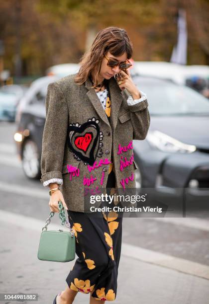 Natasha Goldenberg wearing jacket with print, slippers, dress with floral print, green bag is seen outside Chanel during Paris Fashion Week...