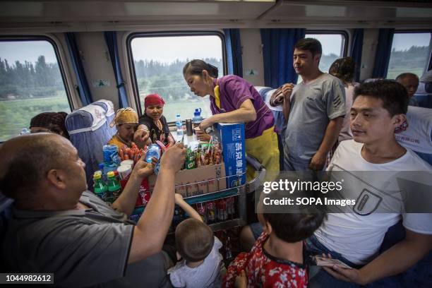 Uyghur and Han Chinese seen buying food at a local vendor inside a train from Hotan to Kashgar in Xinjiang Uyghur Autonomous Region in China. Kashgar...