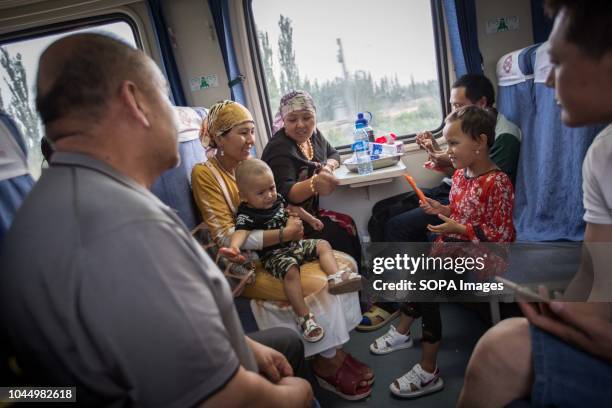 Uyghur and Han Chinese seen spending time inside a train from Hotan to Kashgar in Xinjiang Uyghur Autonomous Region in China. Kashgar is located in...