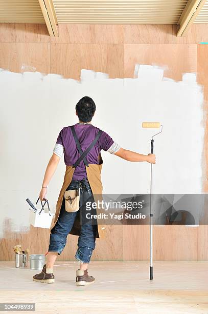 man painting wall, rear view - schürze mann rückansicht stock-fotos und bilder