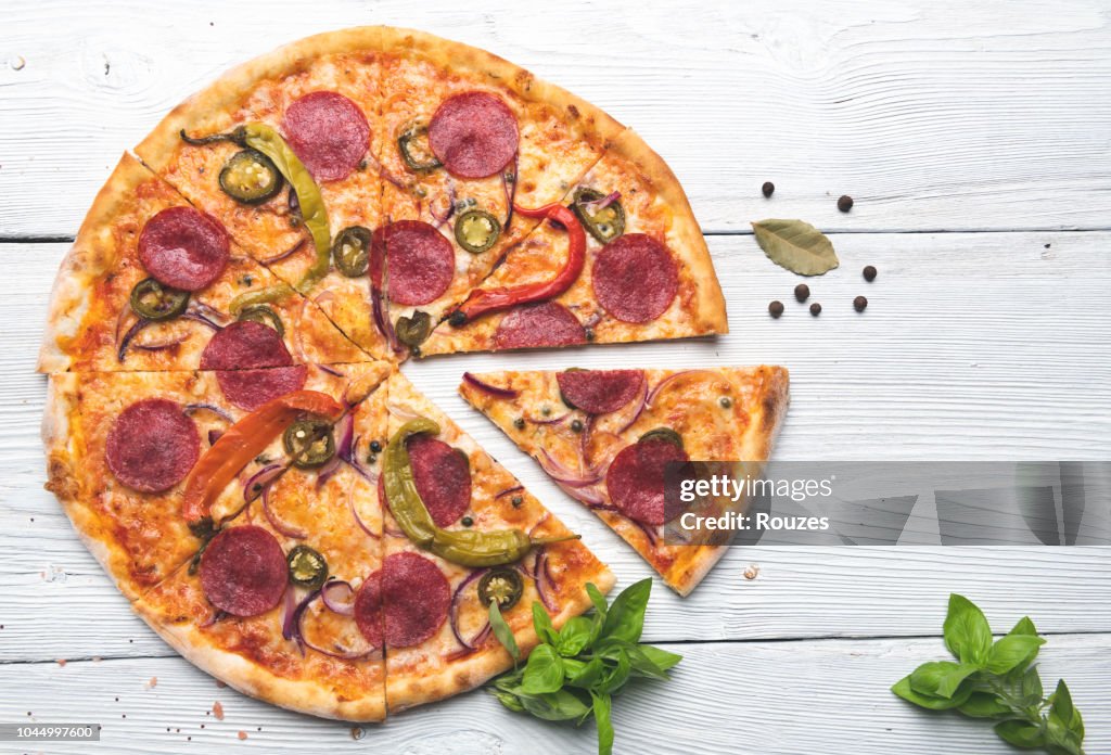 Leckere Pizza isoliert auf weißem Hintergrund aus Holz