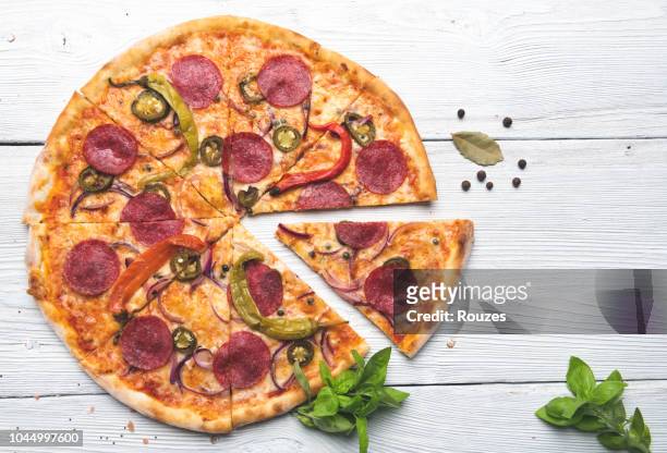 delicious pizza isolated on white wooden background - pepperoni pizza overhead stock pictures, royalty-free photos & images
