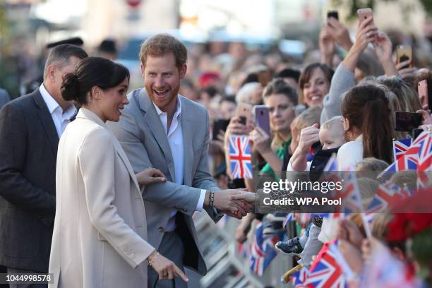 Meghan, Duchess of Sussex and Prince Harry, Duke of Sussex greet well-wishers as they arrive for an engagement at Edes House during an official visit...