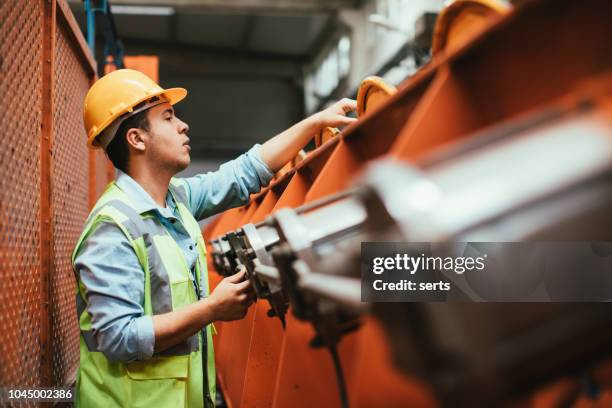 portret van jonge werknemers man werken met kogelkranen in fabriek - compressor stockfoto's en -beelden