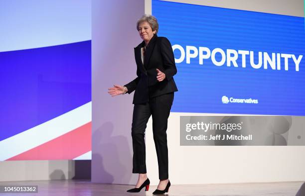 British Prime Minister Theresa May dances as she walks out onto the stage to deliver her leader's speech during the final day of the Conservative...