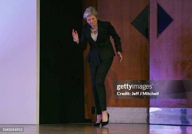 British Prime Minister Theresa May dances as she walks out onto the stage to deliver her leader's speech during the final day of the Conservative...