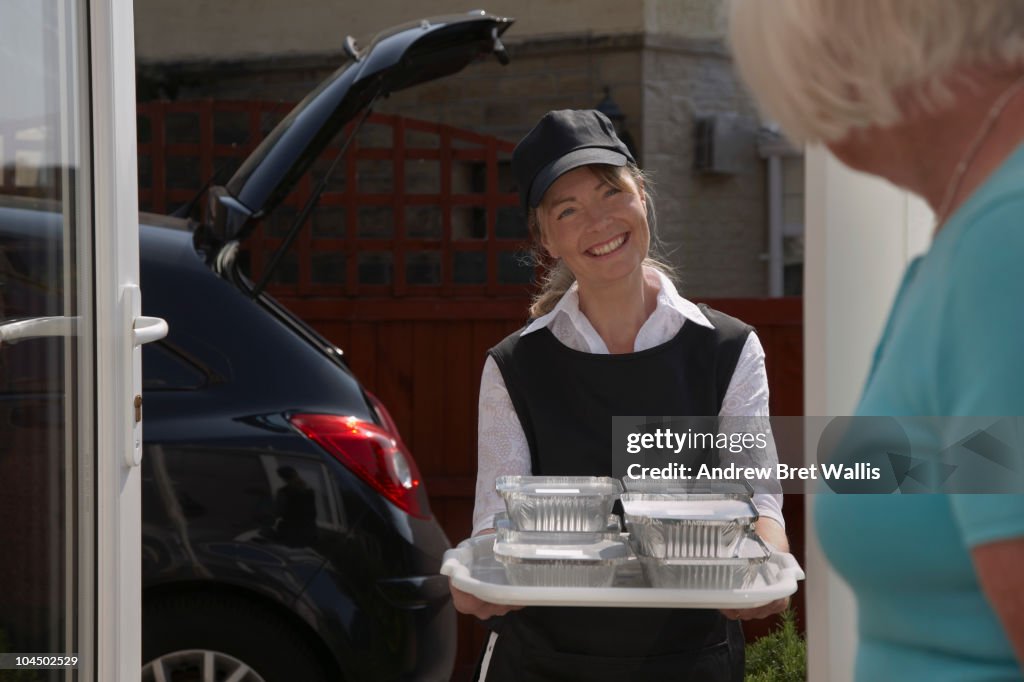 Volunteer delivering meals to an elderly woman