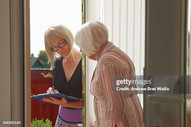 elderly woman talking to doorstop researcher - petición fotografías e imágenes de stock