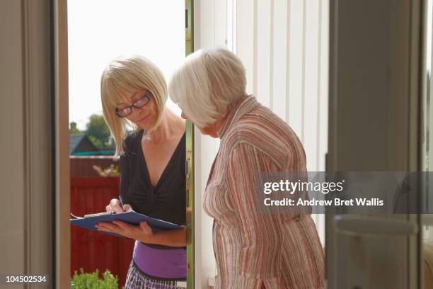 elderly woman talking to doorstop researcher - petition stock pictures, royalty-free photos & images